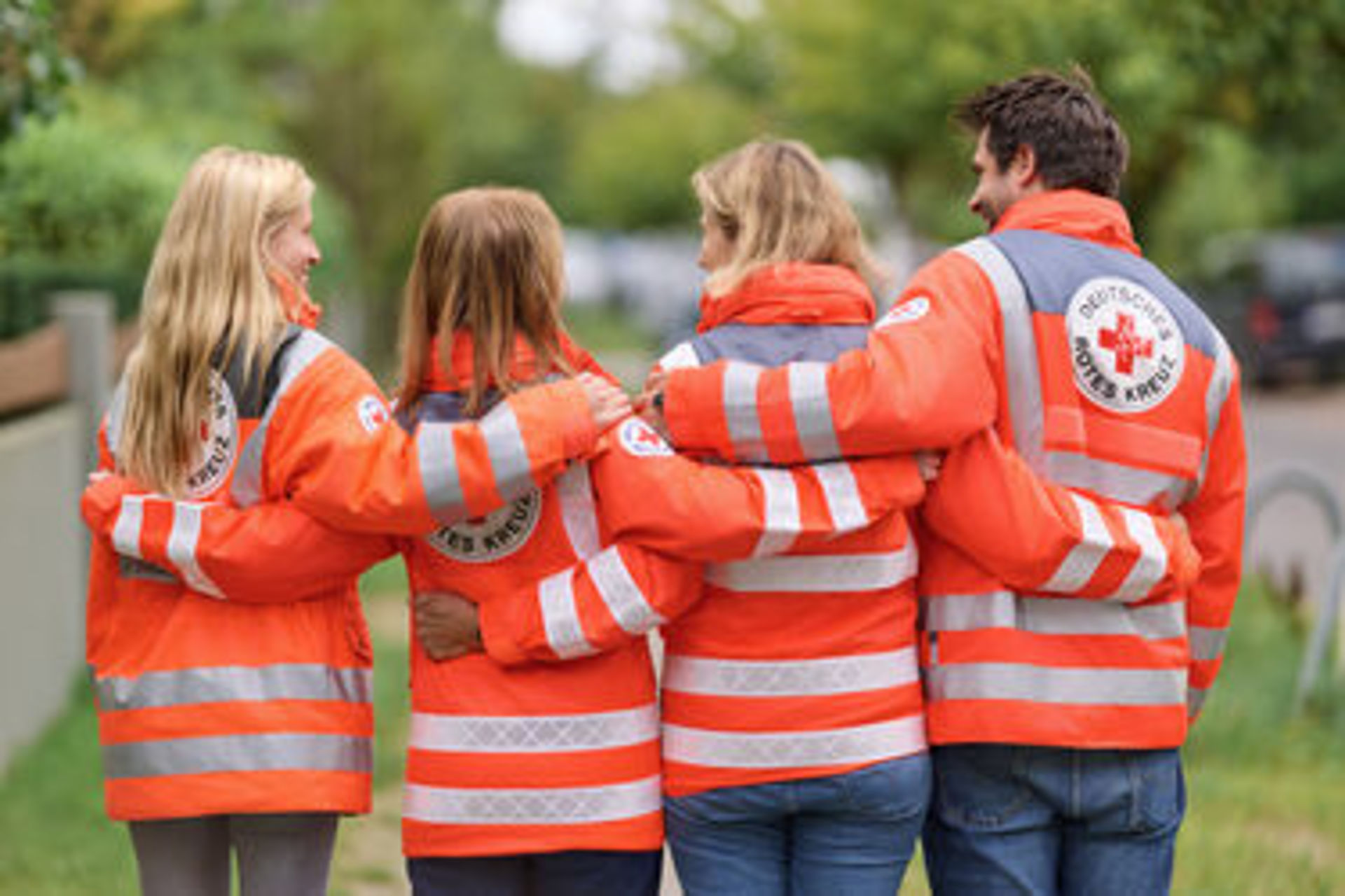 4 Menschen, Arm in Arm Rückenansicht